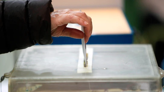 Una persona deposita su papeleta en una urna.  Elecciones gallegas 12-J