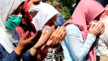 Mujeres rezando en el 25 aniversario de la masacre