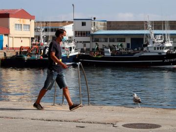 Un trabajador camina por el puerto de Burela, el municipio de A Mariña con más afectados por el brote de coronavirus. Un trabajador camina por el puerto de Burela, el municipio de A Mariña con más afectados por el brote de coronavirus.
