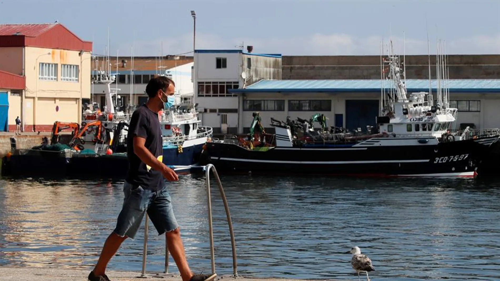 Un trabajador camina por el puerto de Burela, el municipio de A Mariña con más afectados por el brote de coronavirus.