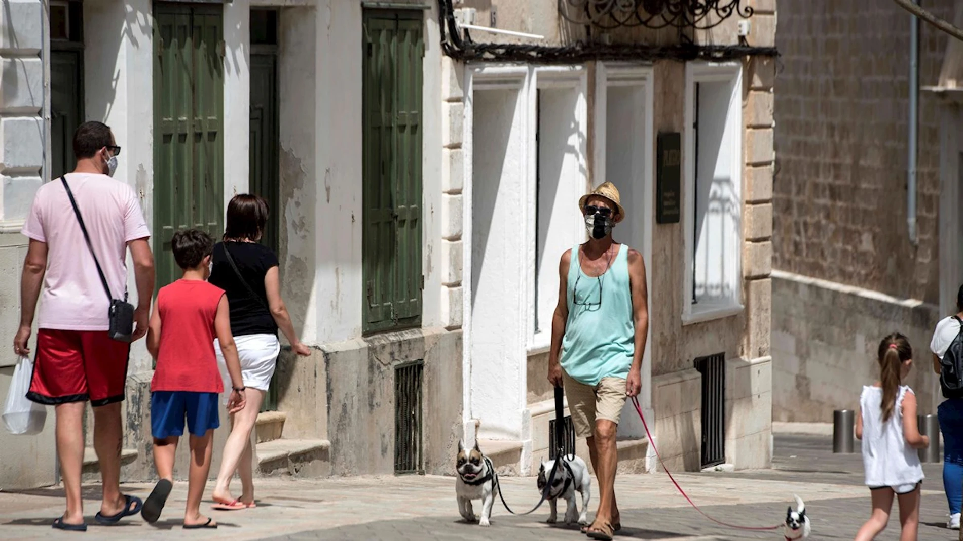 Varias personas caminan por las calles de Mahón (Menorca, España)