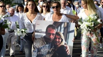 La mujer del fallecido sostiene un retrato junto a su marido durante una marcha en Bayona