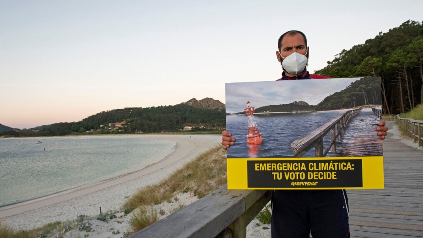 Un activista de Greenpeace sujeta un cartel en el que alerta de la emergencia clim&aacute;tica