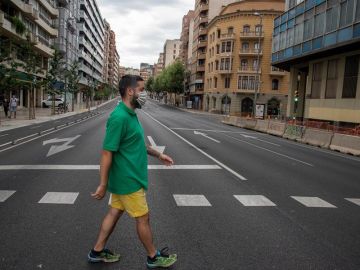 Un vecino cruza la calle en una avenida prácticamente vacía en Lleida Un vecino cruza la calle en una avenida prácticamente vacía en Lleida