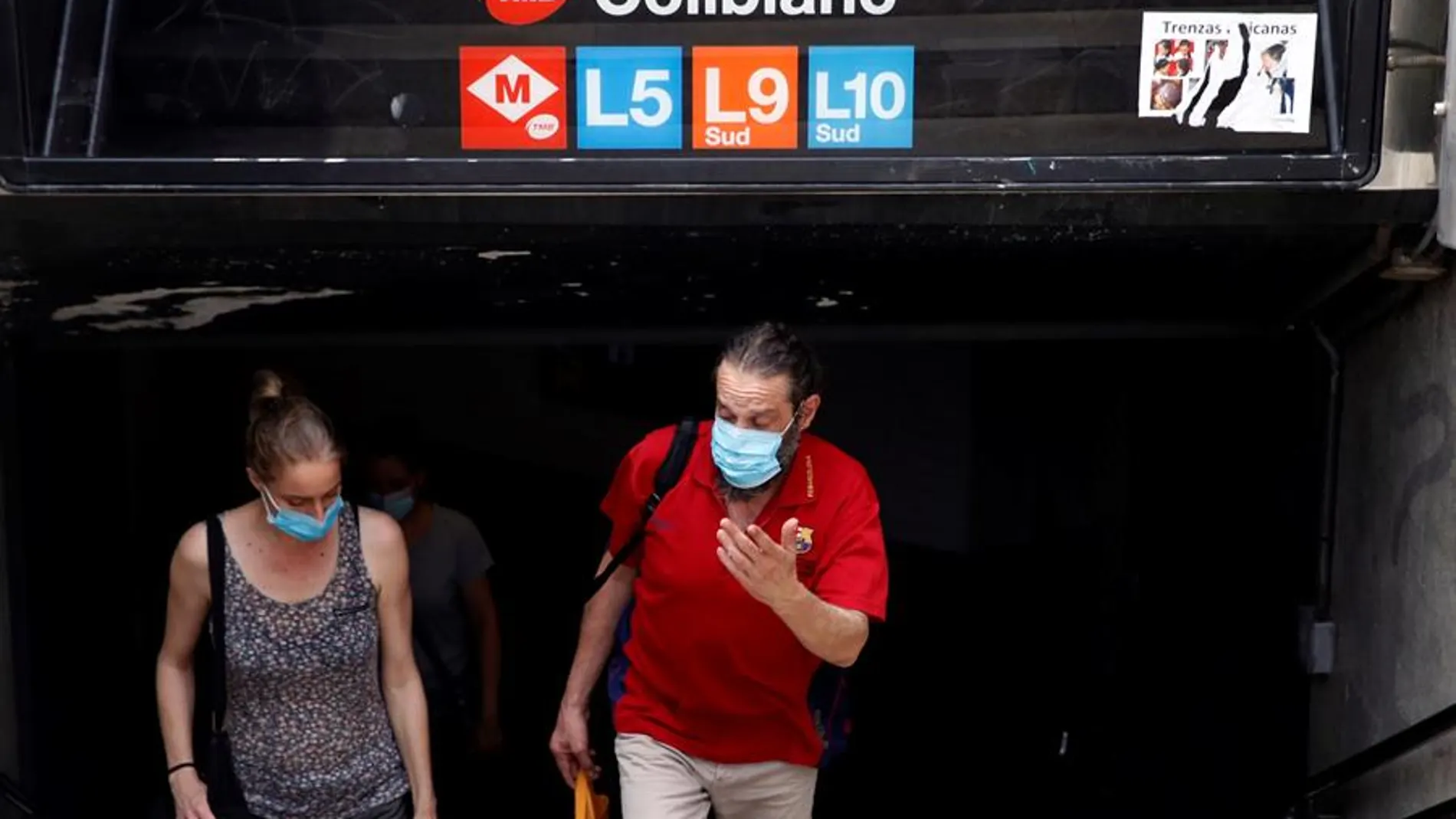 Viajeros salen con mascarilla del metro de Barcelona