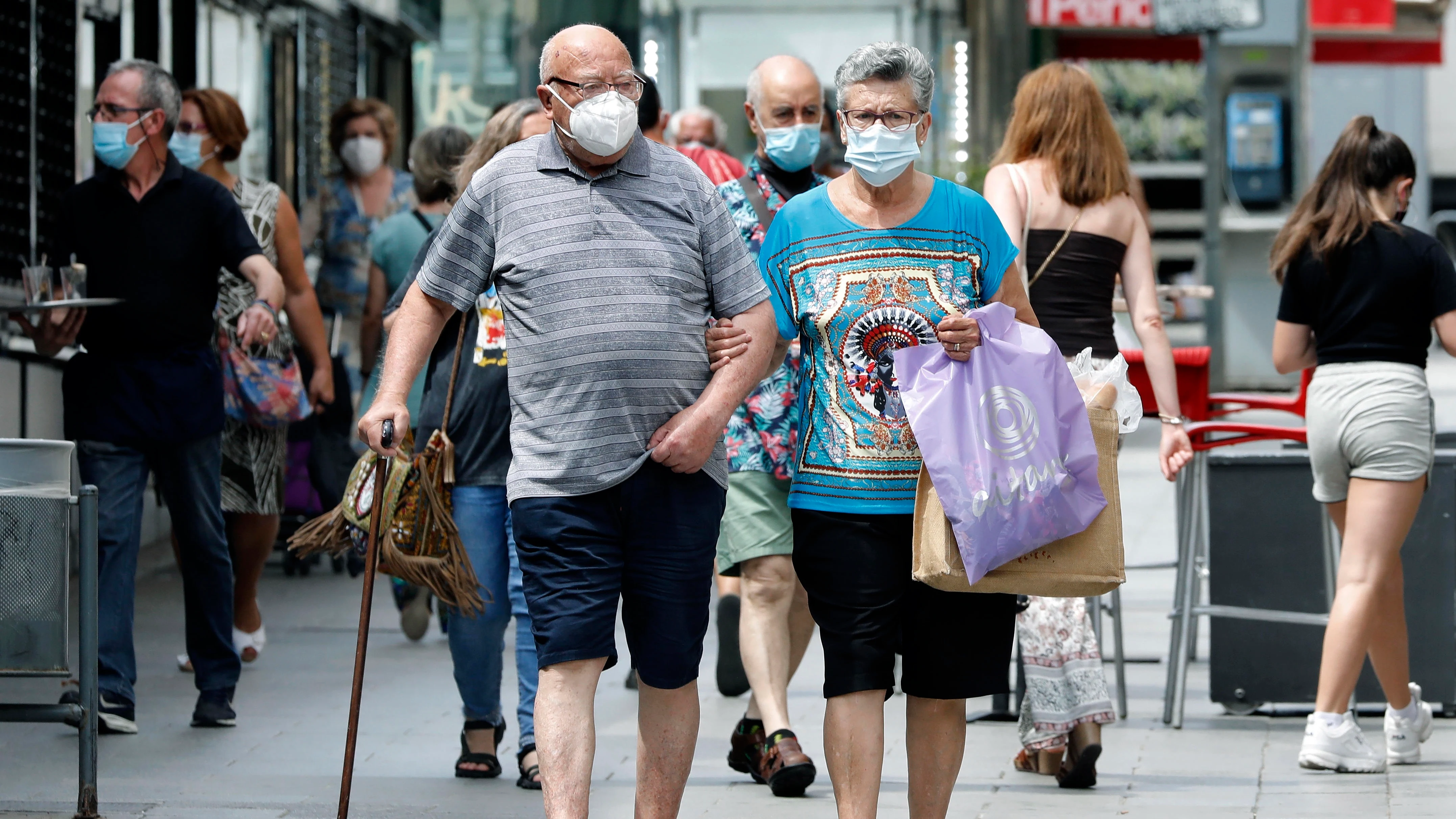 Varias personas en los alrededores del mercado del barrio de Collblanc de L'Hospitalet (Barcelona)