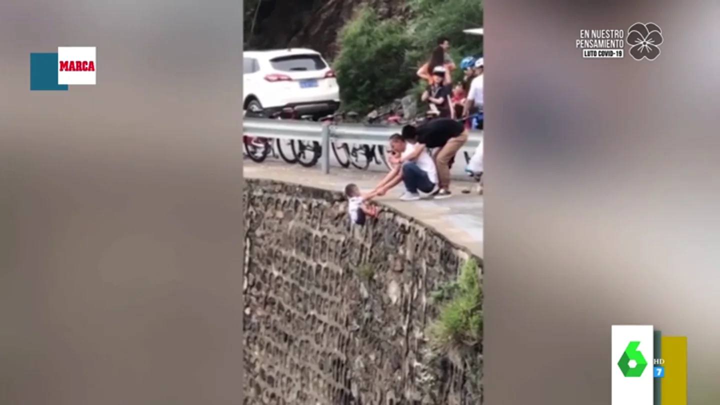 Impactante imagen: deja colgando a su hijo en un acantilado para sacarle una foto Impactante imagen: deja colgando a su hijo en un acantilado para sacarle una foto