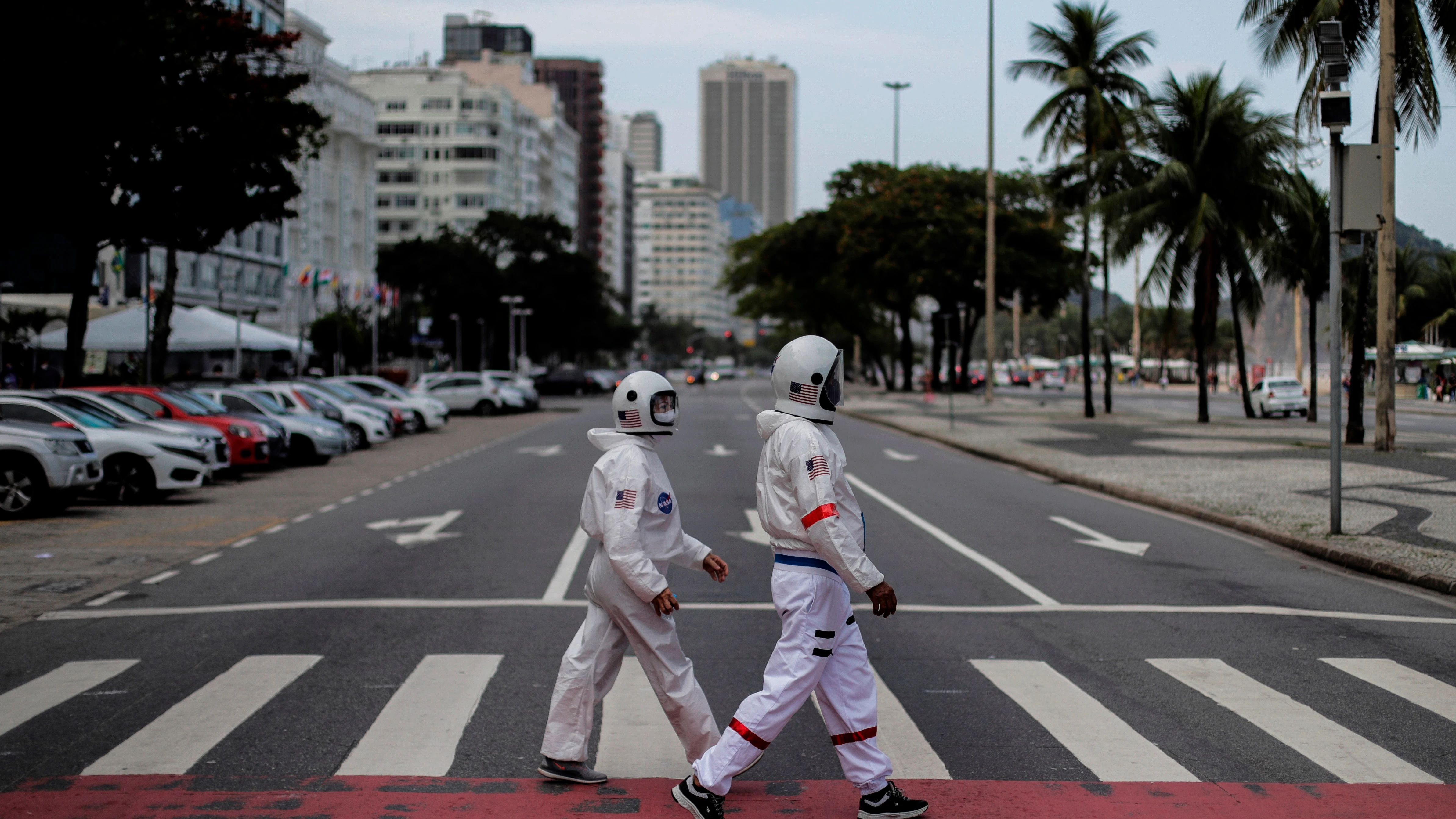 Tercio Galdino y su esposa, Alicea Galdino, caminan por la playa de Leme vestidos de astronautas