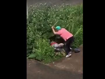 Una mujer golpea violentamente a una pareja que practica sexo en un arbusto Una mujer golpea violentamente a una pareja que practica sexo en un arbusto