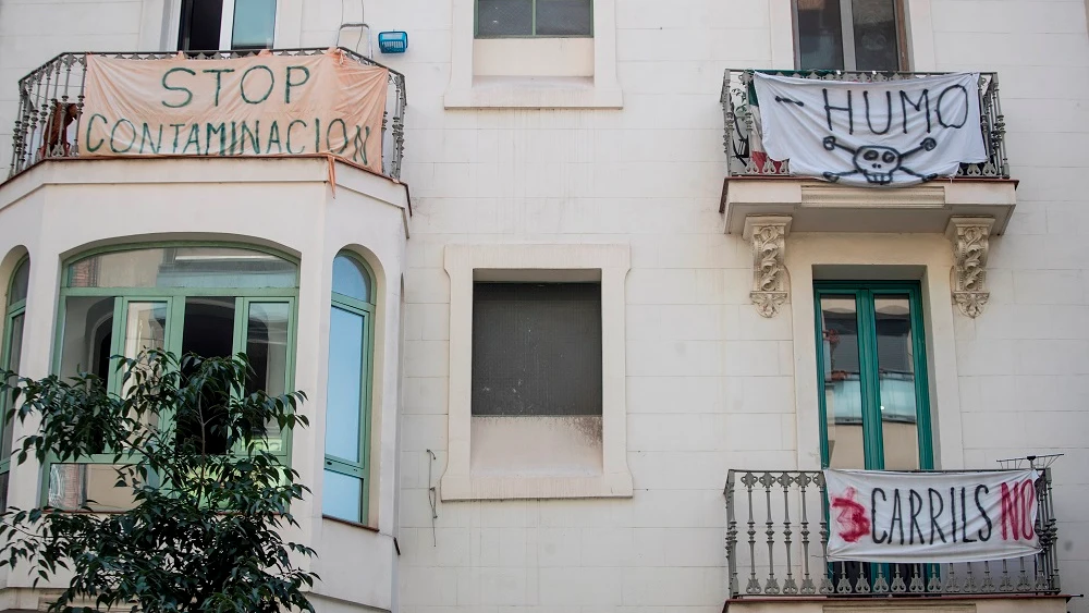 Vista de varios carteles contra la contaminación en un barrio de Barcelona