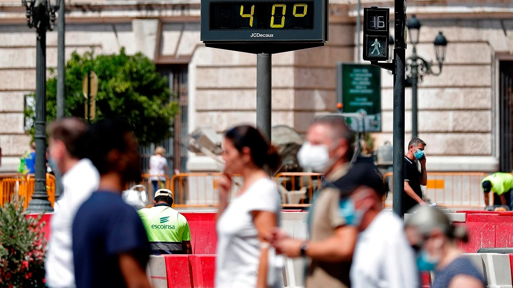 Imagen de personas caminando por la calle a 40 grados