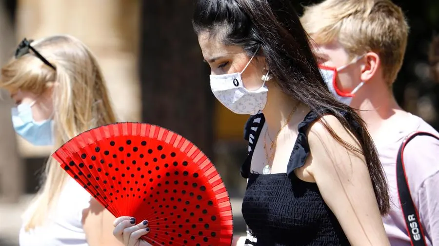 Varias mujeres caminan con mascarilla