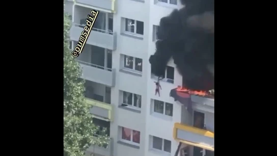 Imagen del momento en el que el hermano mayor cuelga de la ventana al pequeño para que lo cojan los vecinos Imagen del momento en el que el hermano mayor cuelga de la ventana al pequeño para que lo cojan los vecinos