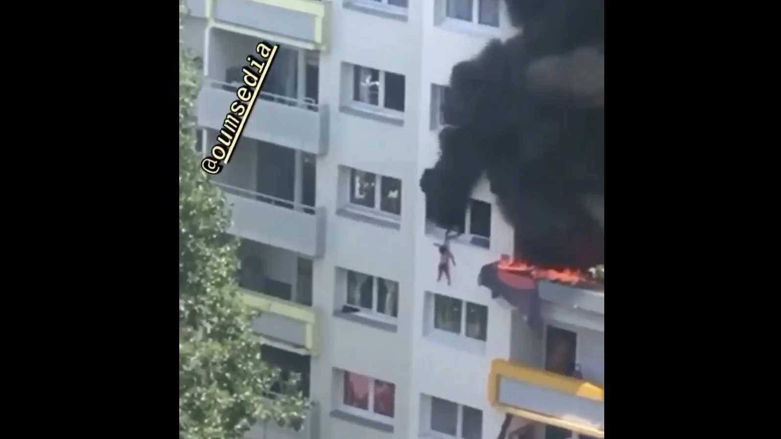 Imagen del momento en el que el hermano mayor cuelga de la ventana al pequeño para que lo cojan los vecinos