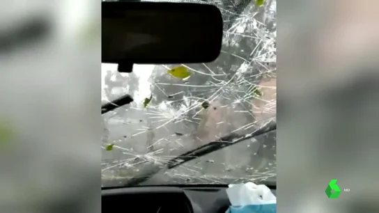 Cristal de un coche destrozado por el granizo Cristal de un coche destrozado por el granizo