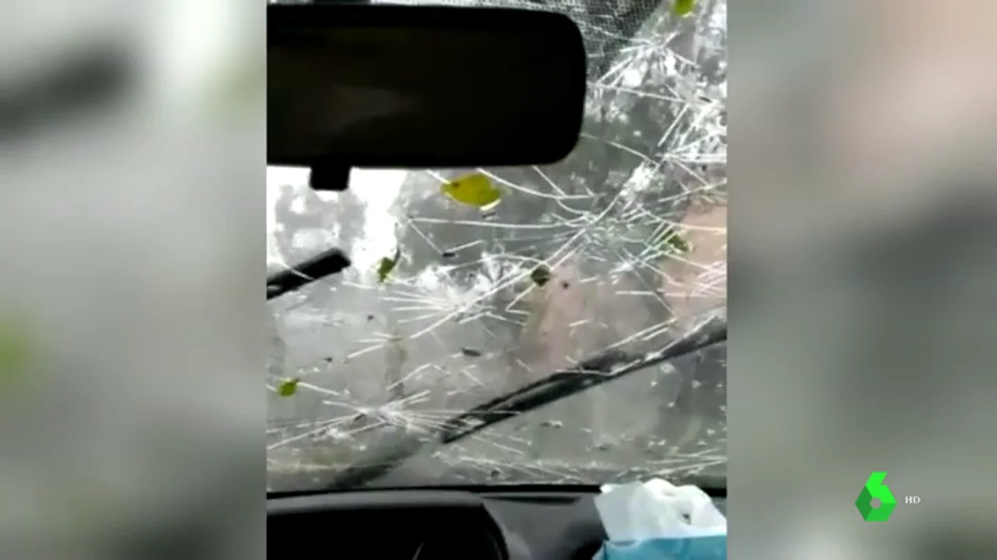 Cristal de un coche destrozado por el granizo Cristal de un coche destrozado por el granizo