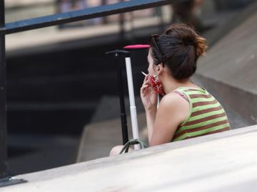 Una mujer fuma en la calle. Una mujer fuma en la calle.