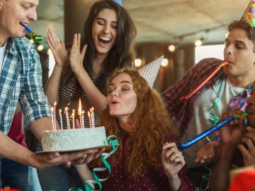 Grupo de amigos soplando las velas en un cumpleaños