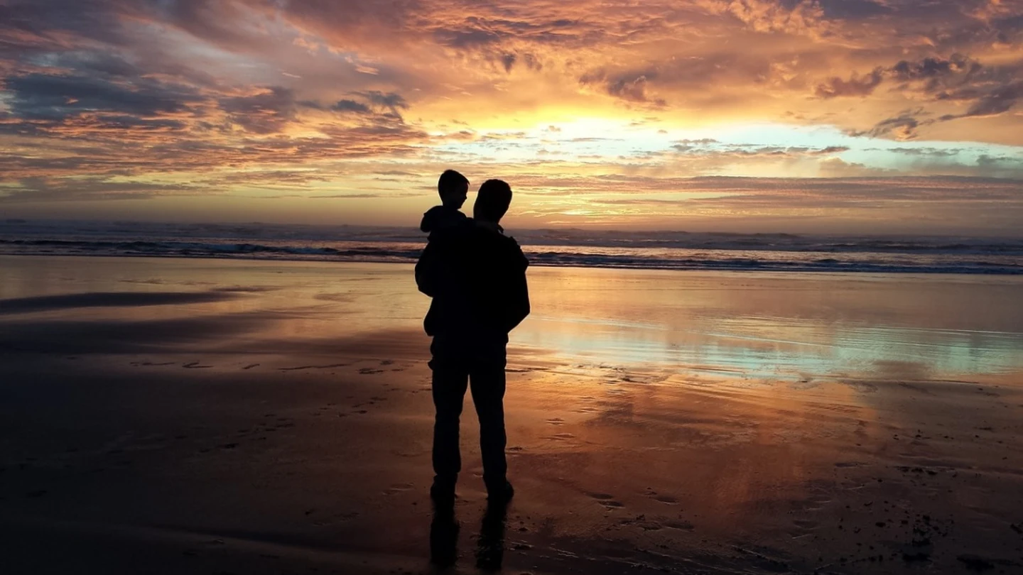Un adulto y un niño frente a la playa Un adulto y un niño frente a la playa