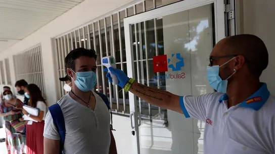 Un sanitario toma la temperatura a una de las personas que esperan su turno para realizarse una prueba de PCR. Un sanitario toma la temperatura a una de las personas que esperan su turno para realizarse una prueba de PCR.
