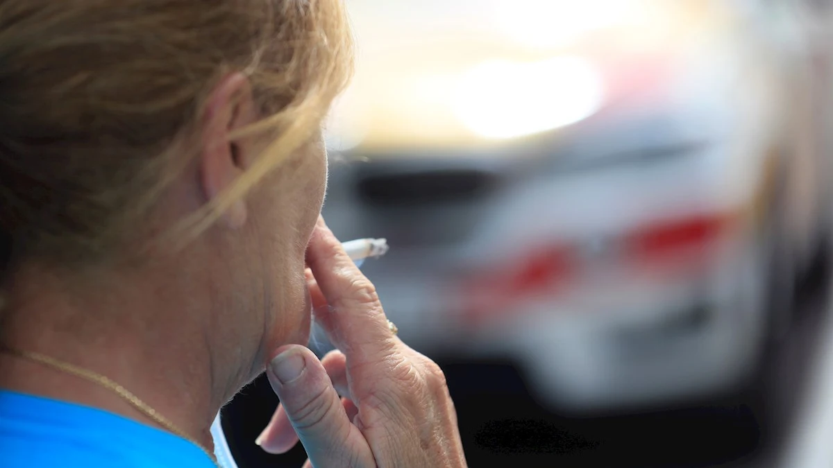 Una mujer se fuma un cigarrillo