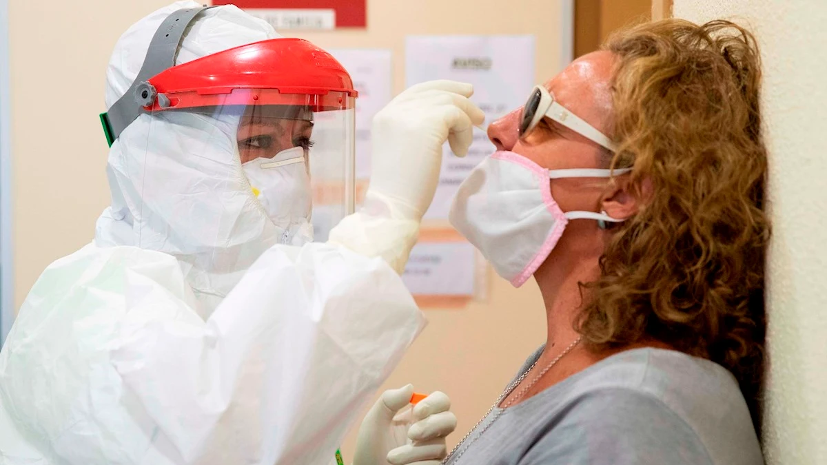 Una enfermera del 061 hace una prueba PCR a una mujer