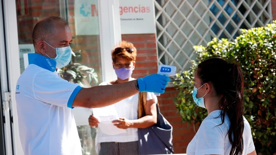 Un paramédico toma la temperatura a una ciudadana antes de acceder al centro de salud Un paramédico toma la temperatura a una ciudadana antes de acceder al centro de salud