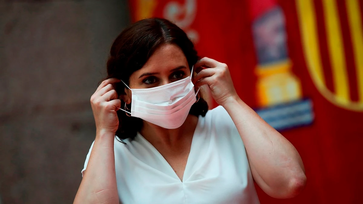 Imagen de Ayuso colocándose una mascarilla