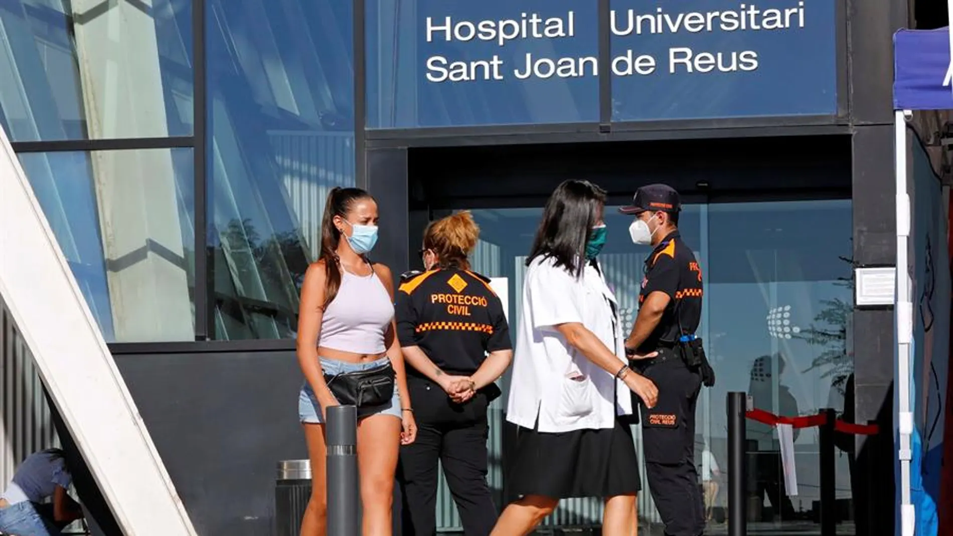  Dos jóvenes salen del Hospital Universitario Sant Joan de Reus (Tarragona), dondese han reanudado los cribados masivos de PCR.