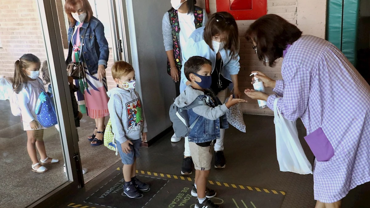 Varios niños entrando al colegio con mascarilla