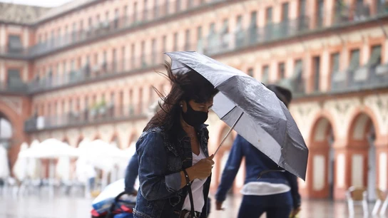 Imagen de una mujer con un paraguas para protegerse de la lluvia Imagen de una mujer con un paraguas para protegerse de la lluvia