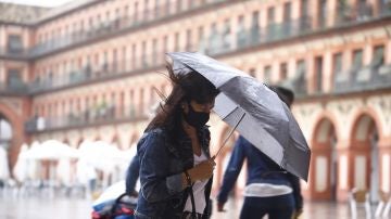 Imagen de una mujer con un paraguas para protegerse de la lluvia