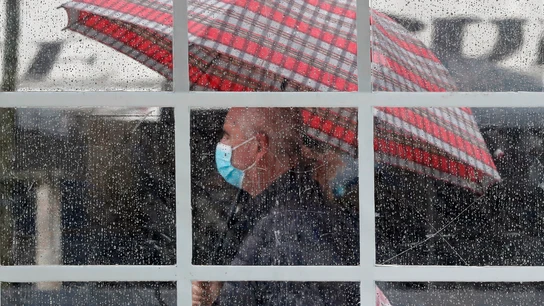 Una persona se protege con un paraguas del agua de la lluvia Una persona se protege con un paraguas del agua de la lluvia