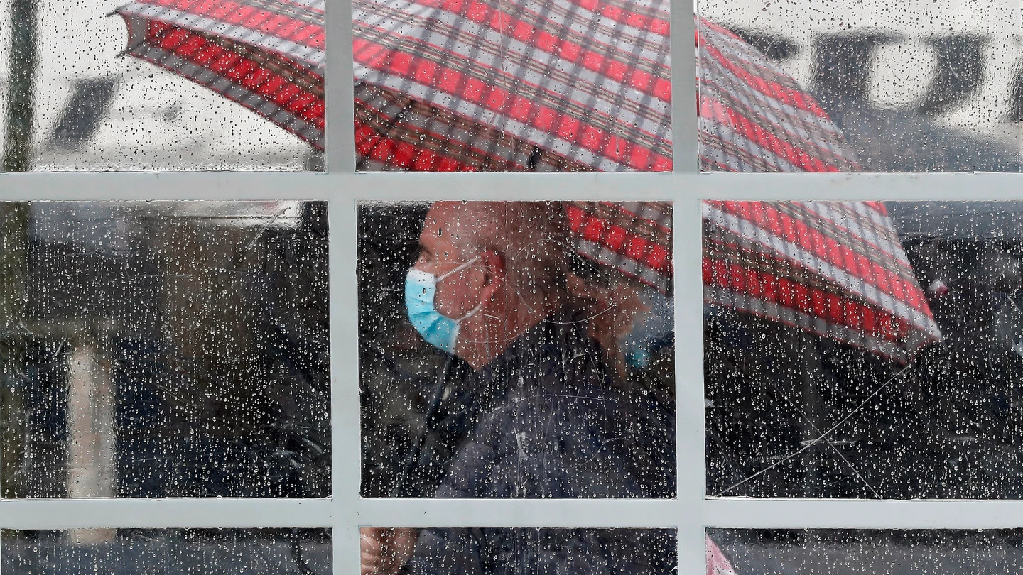 Una persona se protege con un paraguas del agua de la lluvia Una persona se protege con un paraguas del agua de la lluvia