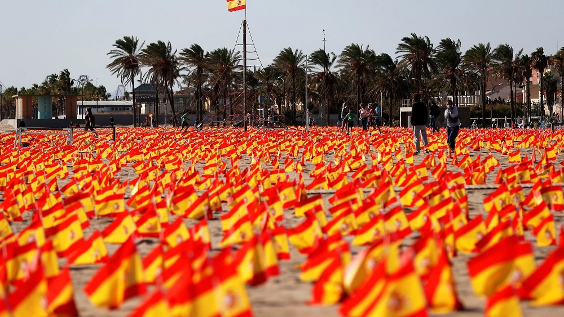 Imagen de las banderas colocadas en una playa de Valencia en homenaje a las víctimas del COVID-19