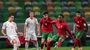 Los jugadores portugueses intentan frenar un pase de Reguilón