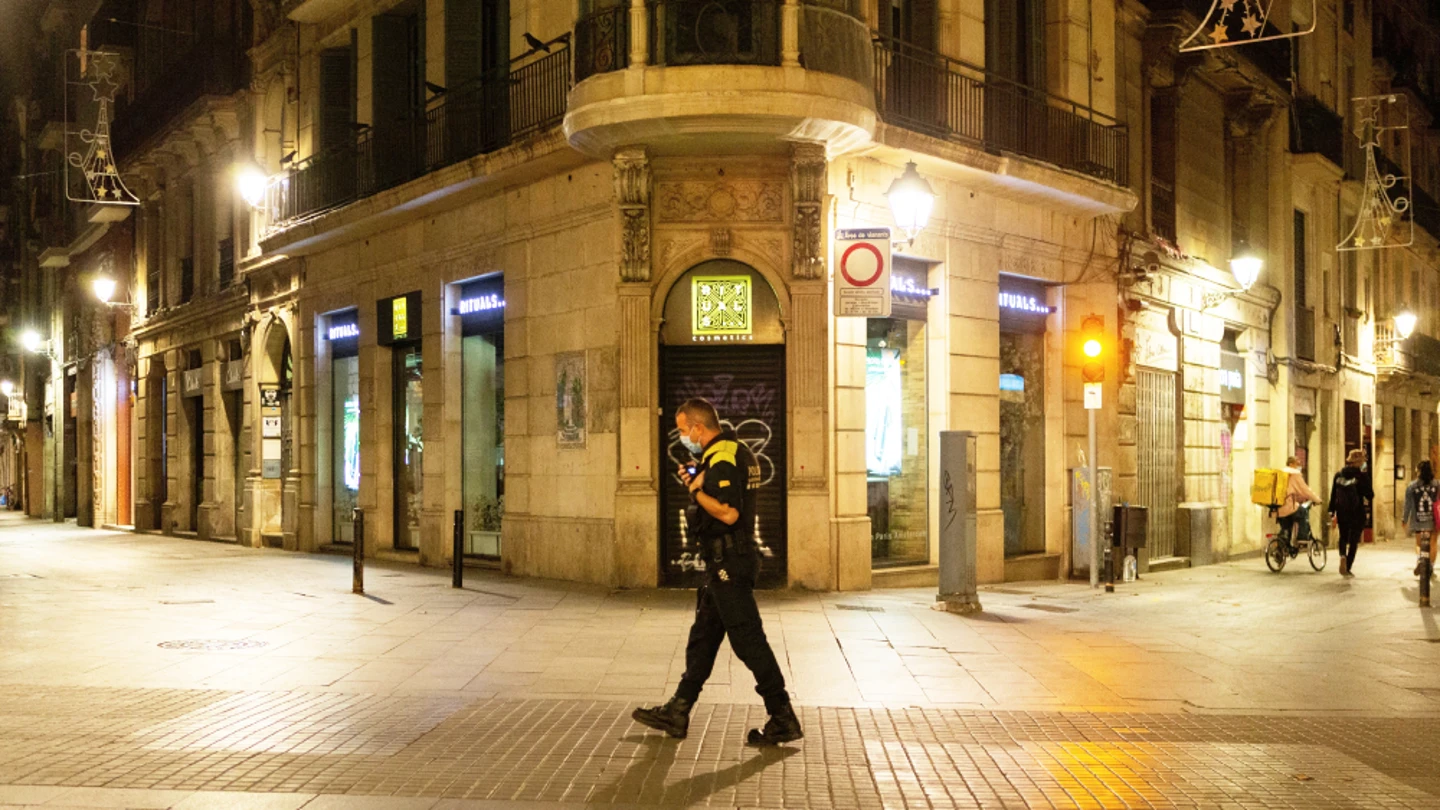 Imagen de archivo de un policía caminando en el toque de queda Toque de queda: ¿qué es?, ¿cómo se aplica en España?