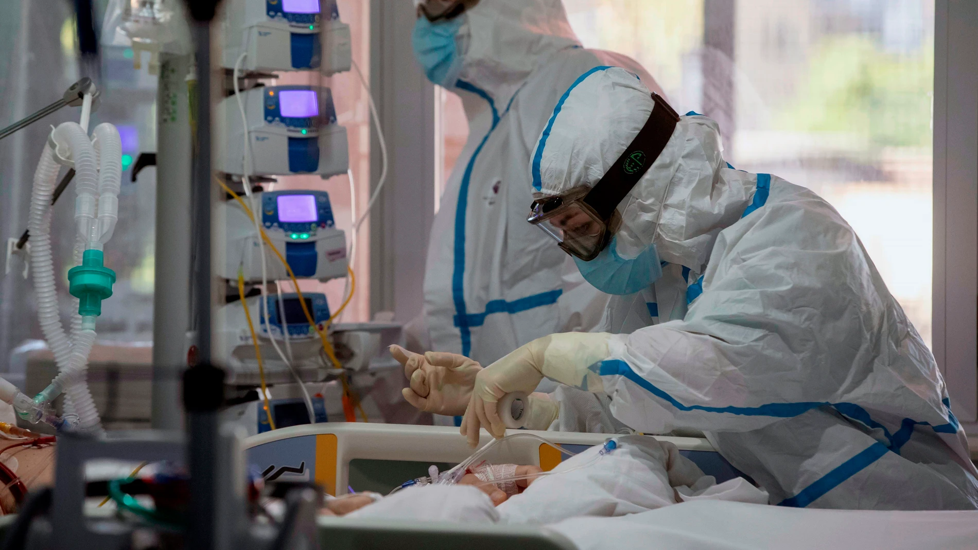 Dos enfermeras atienden a un paciente COVID grave en la UCI