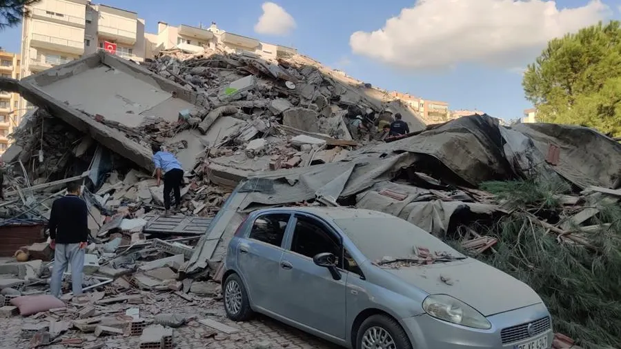 Dos personas buscan en los escombros tras el terremoto que ha sacudido Turquía.