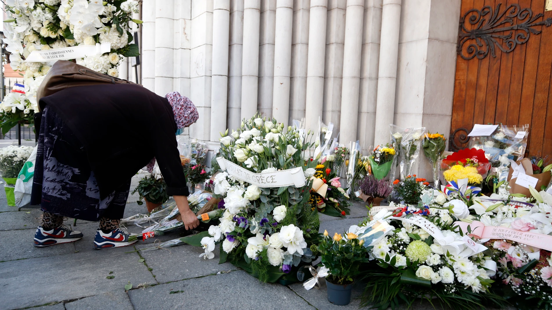 Una mujer deja una flor en recuerdo a las víctimas del ataque terrorista en Niza