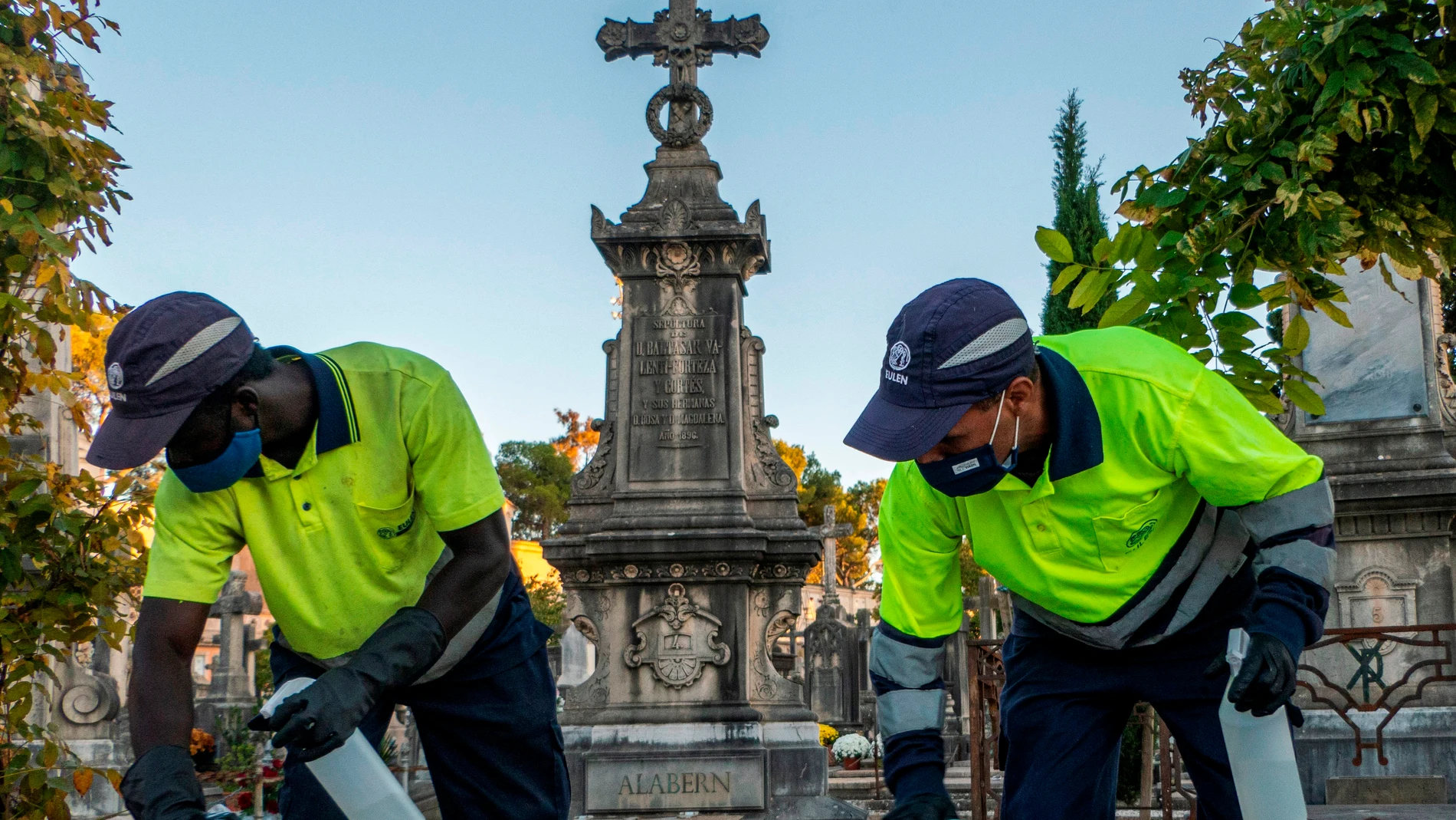 Dos empleados realizan labores de limpieza y desinfección en el cementerio de Palma
