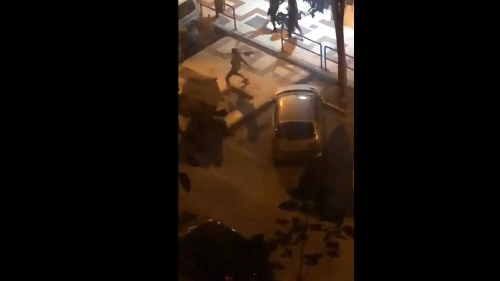 Un violento tira un contenedor durante los disturbios en Málaga