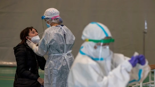 Imagen de una sanitaria haciendo una PCR a una mujer Imagen de una sanitaria haciendo una PCR a una mujer