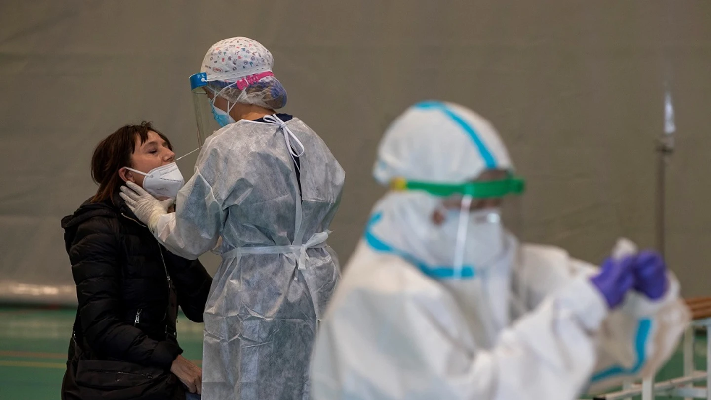 Imagen de una sanitaria haciendo una PCR a una mujer Imagen de una sanitaria haciendo una PCR a una mujer