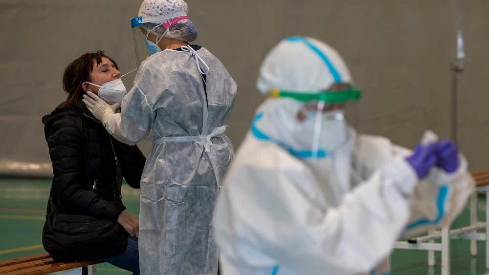 Imagen de una sanitaria haciendo una PCR a una mujer