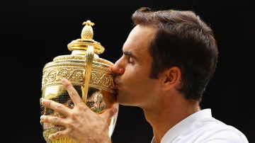 Roger Federer besando su título de Wimbledon