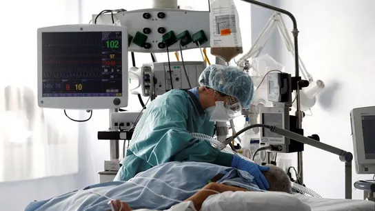 Una médico trata a un paciente de COVID-19 en una UCI. Una médico trata a un paciente de COVID-19 en una UCI.