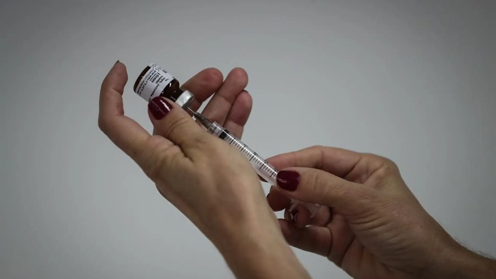 Una enfermera se prepara para aplicar una vacuna