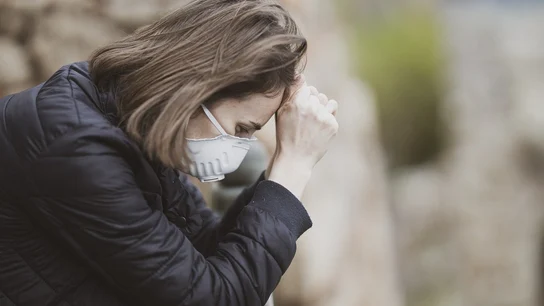 Una mujer con mascarilla sufre un ataque de ansiedad Una mujer con mascarilla sufre un ataque de ansiedad
