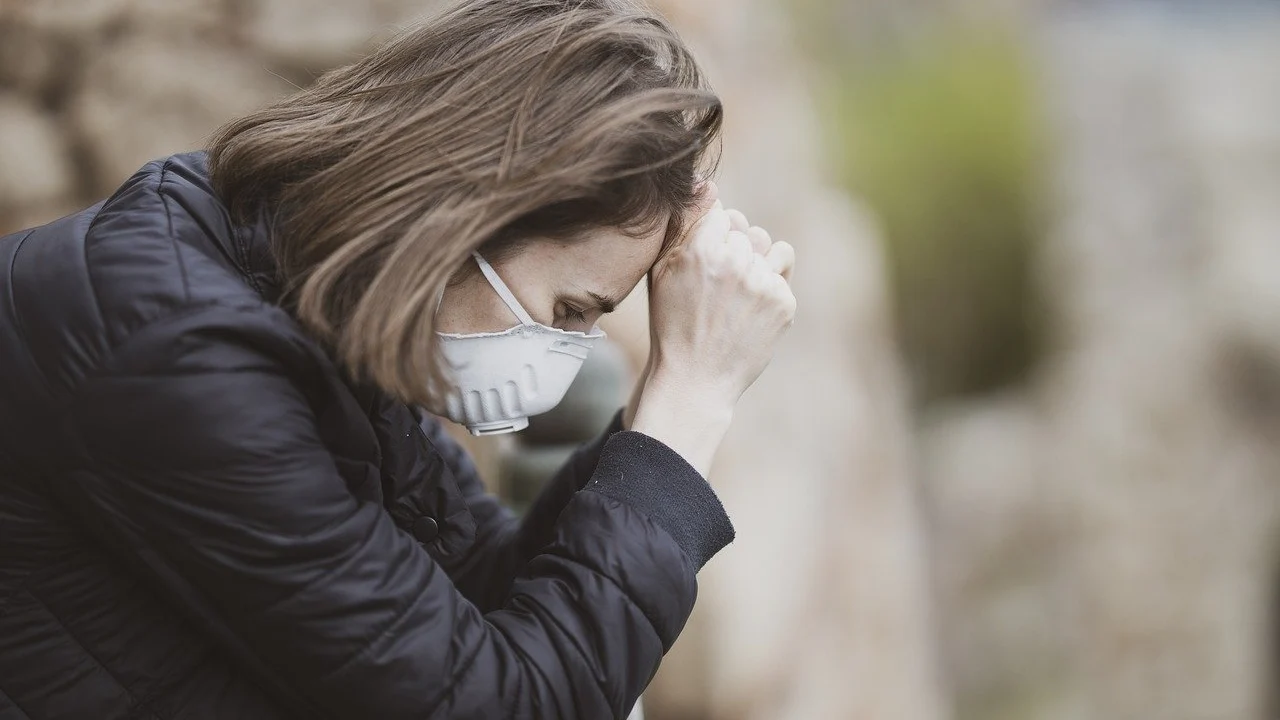 Una mujer con mascarilla sufre un ataque de ansiedad